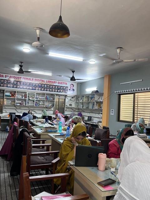 Female students at work under the martyrs' banner