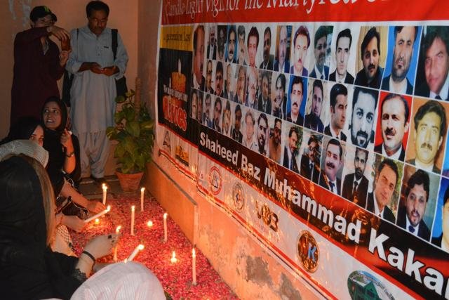 Candles lit before the martyrs' portraits
